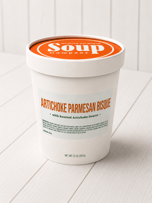 Container of Artichoke Parmesan Bisque from the Soup Company on a white wooden surface
