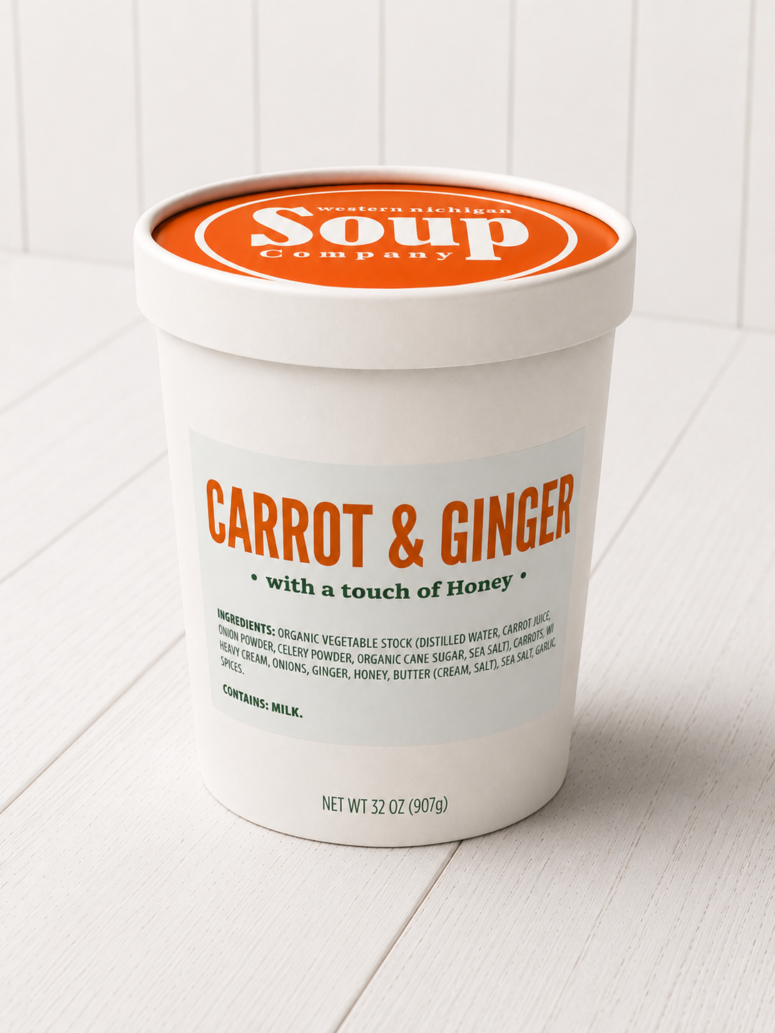 Container of 'Carrot & Ginger' soap with Honey on a white background