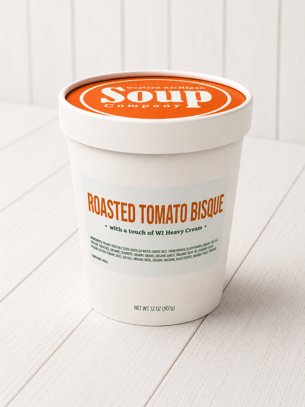 Container of roasted tomato bisque with 'Modern Atelier Soup Company' branding on a white background